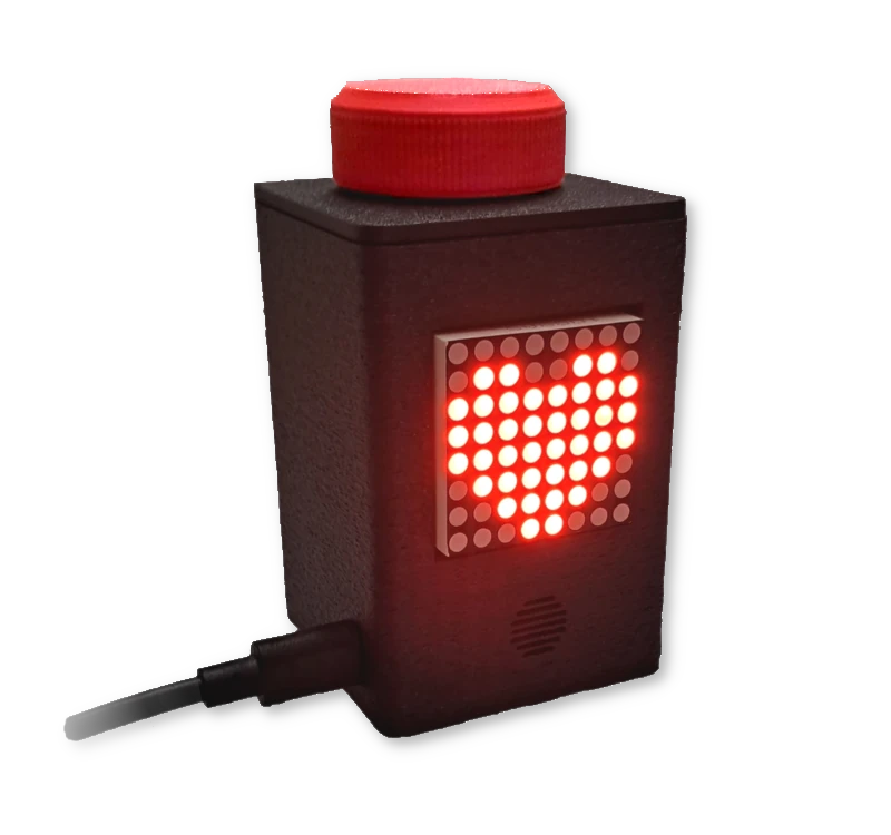 Product photo of the Attention Button. The device is a black cuboid with a square base, about two times tall as it is wide. It is displayed at a 45-degree angle showing two faces and the top of the device. The left face has a port for powering the device. The right face has an 8x8 LED matrix showing a pixel drawing of a heart. The top has a knob that doubles as a button.